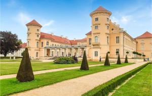 a large building with trees in front of it at Cozy Ship In Rheinsberg Hafendorf With House Sea View in Rheinsberg