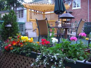 a patio with a bunch of flowers and an umbrella at B&B Le Transit in Quebec City