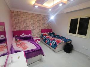 1 Schlafzimmer mit 2 Betten und einem Spiegel in der Unterkunft apartment Mokattam Cairo in Kairo