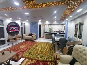 ein Wohnzimmer mit einem TV, Stühlen und einem Teppich in der Unterkunft apartment Mokattam Cairo in Kairo