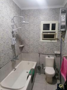 ein Bad mit einer Badewanne, einem WC und einer Klimaanlage in der Unterkunft apartment Mokattam Cairo in Kairo