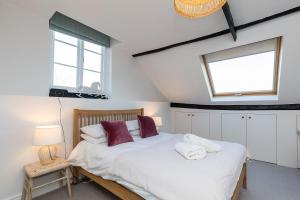 a bedroom with a bed with two pillows and a window at Barn Cottage -Westerlands in Graffham