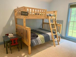 a wooden bunk bed with a ladder and a table at Highland Woods - Private home on 37 acres with stunning mountain views in Shaftsbury