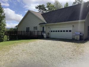 a house with a white garage with a black roof at Highland Woods - Private home on 37 acres with stunning mountain views in Shaftsbury
