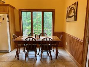 a dining room with a table and chairs and a window at Highland Woods - Private home on 37 acres with stunning mountain views in Shaftsbury