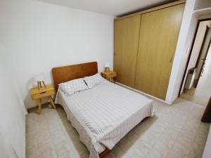 een slaapkamer met een bed en twee nachtkastjes bij Cómodo Departamento de 2 habitaciones, con excelente ubicación in San Rafael