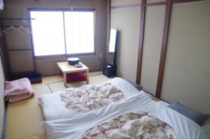 Habitación hospitalaria con cama y mesa en Ryokan Takayama, en Takayama