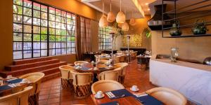 a dining room with tables and chairs and windows at Real de Minas San Miguel de Allende in San Miguel de Allende