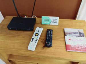 a table with two remote controls and a book at Cómodo Departamento de 2 habitaciones, con excelente ubicación in San Rafael
