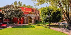 a red building with a yard in front of it at Real de Minas San Miguel de Allende in San Miguel de Allende