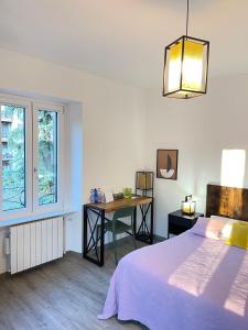 Schlafzimmer mit einem Bett, einem Tisch und einem Fenster in der Unterkunft Smart Gold Apartment Luxury Central in Bergamo