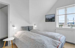 1 dormitorio blanco con 2 camas y ventana en Lovely Apartment In Nex With Wifi, en Neksø