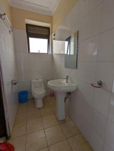 a bathroom with a toilet and a sink at Kasenene Legacy Hotel in Fort Portal