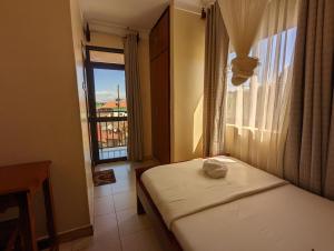 Kasenene Legacy Hotel tesisinde bir odada yatak veya yataklar