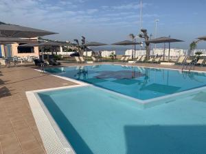 a large blue swimming pool with chairs and umbrellas at Galìa Luxury Resort in Pizzo