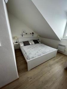 1 dormitorio con 1 cama blanca en el ático en Útulný apartmán na Dolní Moravě, en Dolní Morava