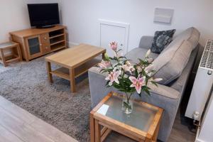 a living room with a vase of flowers on a table at Chy Lowen, great valley views from balcony in Hayle