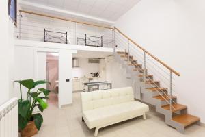a living room with a white couch and a spiral staircase at Appartamenti "Il Delfino" in Lecce