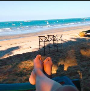 a person with their feet up on a beach at Suíte pé na areia in Icapuí