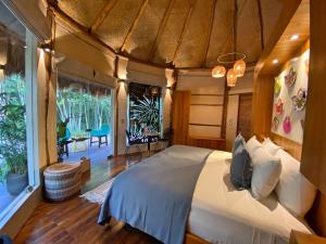 a bedroom with a bed and a large window at Casa Kaan Calakmul in Xpujil