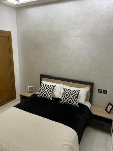 - une chambre avec un lit et des oreillers dans l'établissement Appart luxueux sécurisé parking 10 min Medina, à Fès