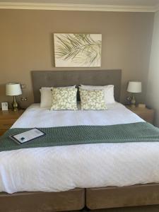 a bedroom with a large bed with a book on it at On The Terrace Stanley in Stanley