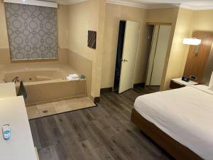 a hotel room with a bed and a bath tub at Best Western Hollywood Plaza Inn Hotel - Hollywood Walk of Fame LA in Los Angeles