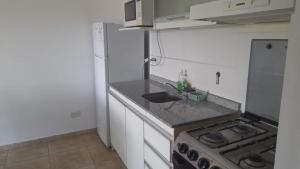 Il comprend une petite cuisine équipée d'un évier et d'une cuisinière. dans l'établissement Departamento JS - Centro Bariloche, à San Carlos de Bariloche