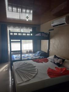 a bedroom with two bunk beds and a window at Apartamentos Caimán Tortuguero in Tortuguero