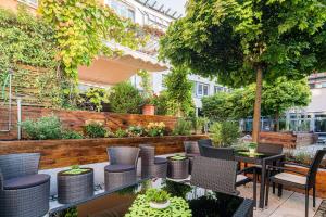 a patio with chairs and tables and a garden at Best Western Hotel Am Straßberger Tor in Plauen