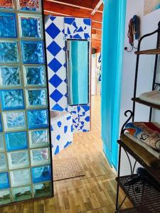 Habitación con azulejos azules y blancos y espejo. en Atico de la Pardela, en La Laguna