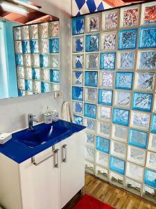 baño con lavabo azul y pared de azulejos de cristal en Atico de la Pardela, en La Laguna