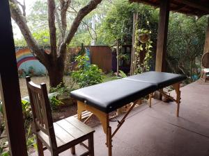 a bench and a chair on a patio at Pousada Recanto Devas in Cabo Frio
