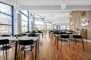 un restaurante con mesas, sillas y ventanas en Best Western Hotel Hillerød, en Hillerød