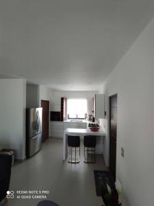 a kitchen with a table and two bar stools at Condominio Palomino en Viñedos del Mar Ensenada privada San Antonio in Ensenada