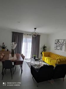 a living room with a yellow couch and a table at Condominio Palomino en Viñedos del Mar Ensenada privada San Antonio in Ensenada