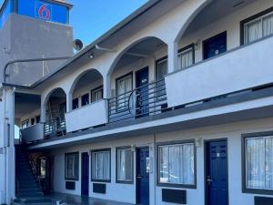 a building with blue doors and a balcony at Motel 6 Richmond CA Civic Center in Richmond