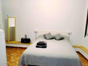 een slaapkamer met een bed met 2 kussens en een spiegel bij La Pernocta in Arucas