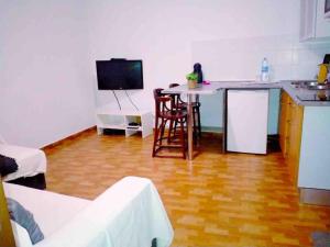 een woonkamer met een keuken en een tafel met een aanrecht bij La Pernocta in Arucas