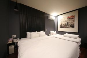 2 Heaven Hotel Songdo في بوسان: سرير أبيض كبير في غرفة الفندق