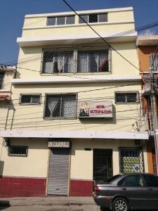 a building with curtains in the windows and a car parked in front at Hotel Metropolitano in Guatemala