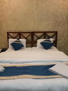 un letto con cuscini blu e bianchi di Dudhwa TigeRhino Resort a Dudwa