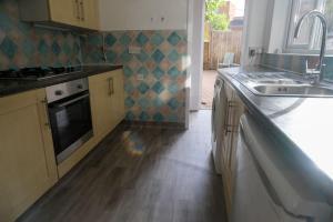 una cucina con lavandino e piano di lavoro di 4 Bedroom House in Turnpike Lane/Wood Green a Londra