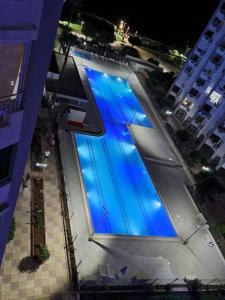 - une grande piscine bleue dans une ville la nuit dans l'établissement Strandhaus direkt am Meer, à Mezitli