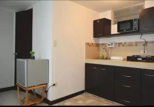 a kitchen with a refrigerator and a microwave at CAMAKING /WIFI/ NETFLIX/ NORTE/ VALLEDEATRIZ/MODERNO in Pasto