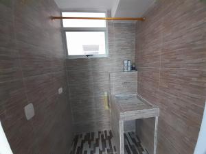 baño con ducha con lavabo y ventana en Acogedor y Hermoso Apartamento Familiar con WiFi, en Santa Marta