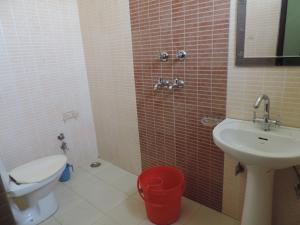 un piccolo bagno con un water e un lavandino di Dudhwa TigeRhino Resort a Dudwa Altre 6 foto