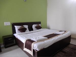 ein großes Bett in einem Schlafzimmer mit grünen Wänden in der Unterkunft Dudhwa TigeRhino Resort in Dudwa