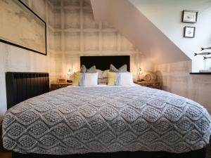 a bedroom with a large white bed with a staircase at Padstow Escapes - Teyr Luxury Penthouse Apartment in Padstow
