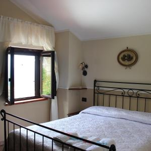 1 dormitorio con cama y ventana en Il giardino del borgo, en Rocca Cilento
